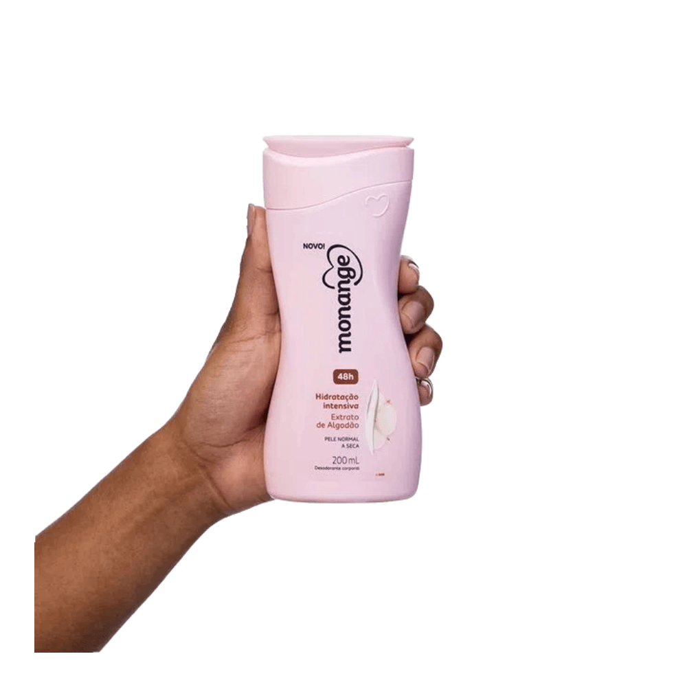 Mão segurando o frasco rosa do Hidratante Corporal Monange 200ml mostrando o rótulo e design ergonômico