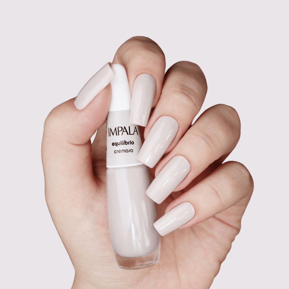 Mão segurando o esmalte Impala Cremoso Equilíbrio com fundo claro