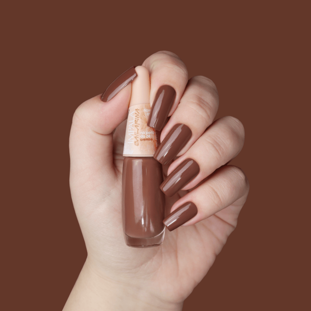 Mão segurando o frasco com unhas pintadas na cor Na Ponta do Pé
