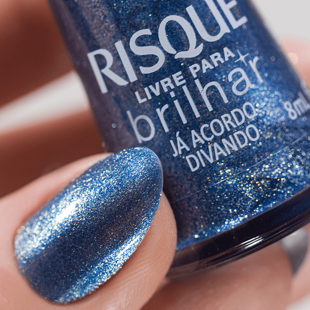 Close do frasco e unha pintada com esmalte azul metálico Risqué
