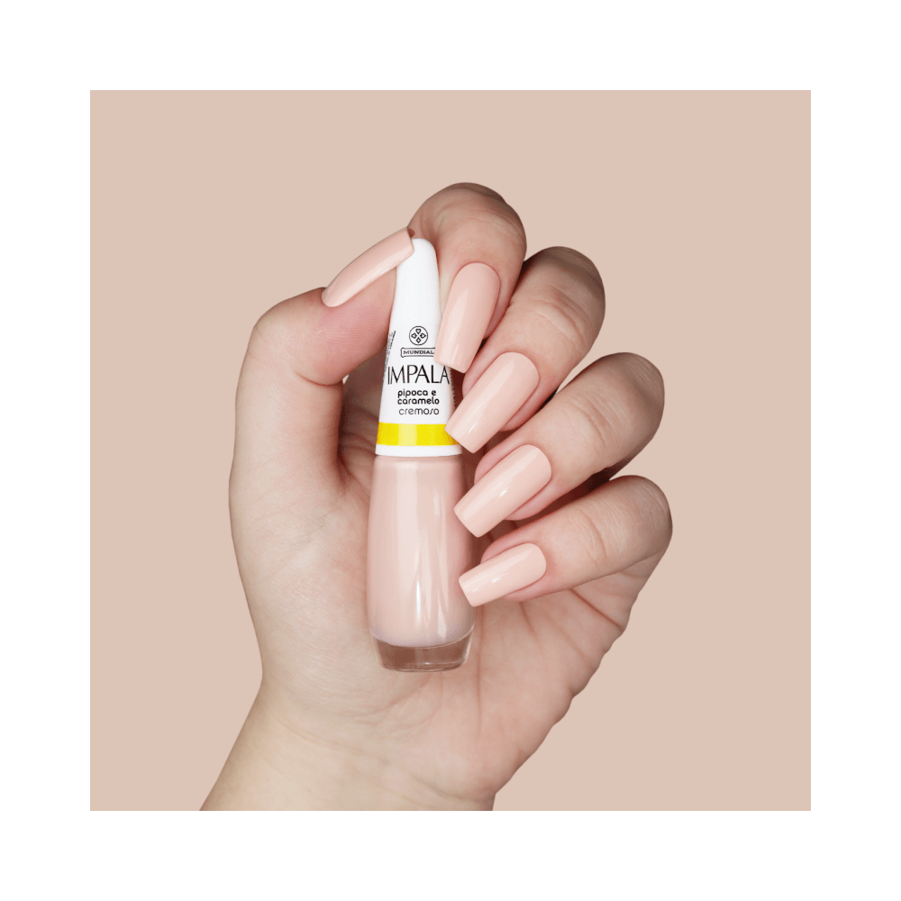 Mão segurando o esmalte Impala Pipoca e Caramelo com unhas pintadas na mesma cor
