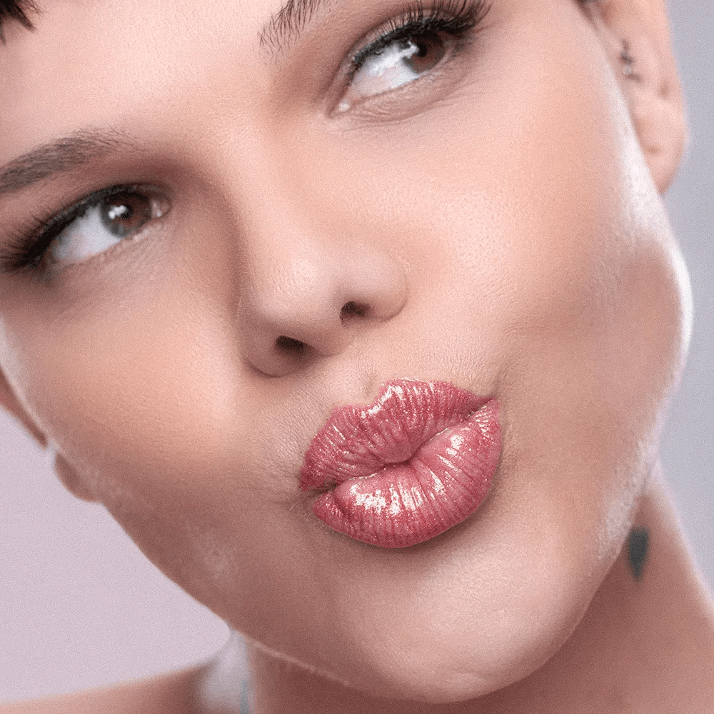 Modelo com o gloss aplicado mostrando brilho intenso e tom Venus