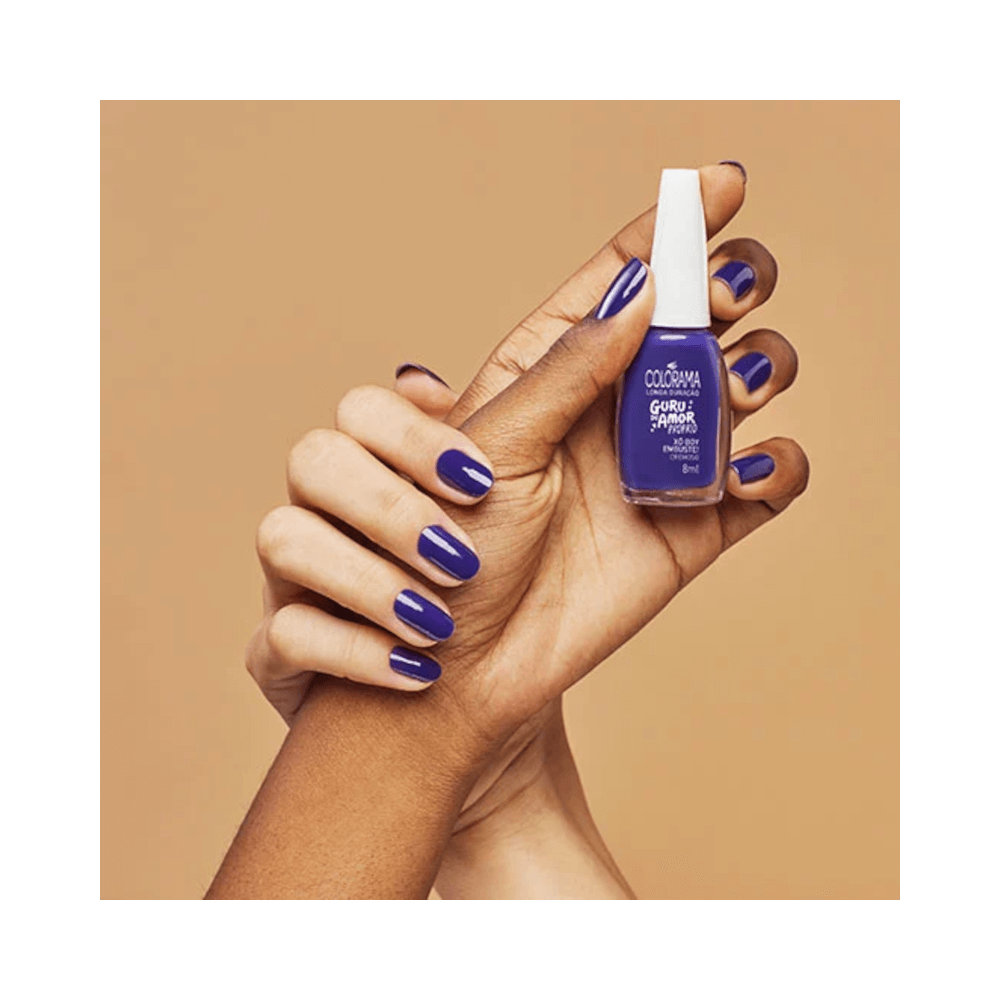 Mão segurando esmalte Colorama Xô Boy Embuste com unhas pintadas na mesma cor