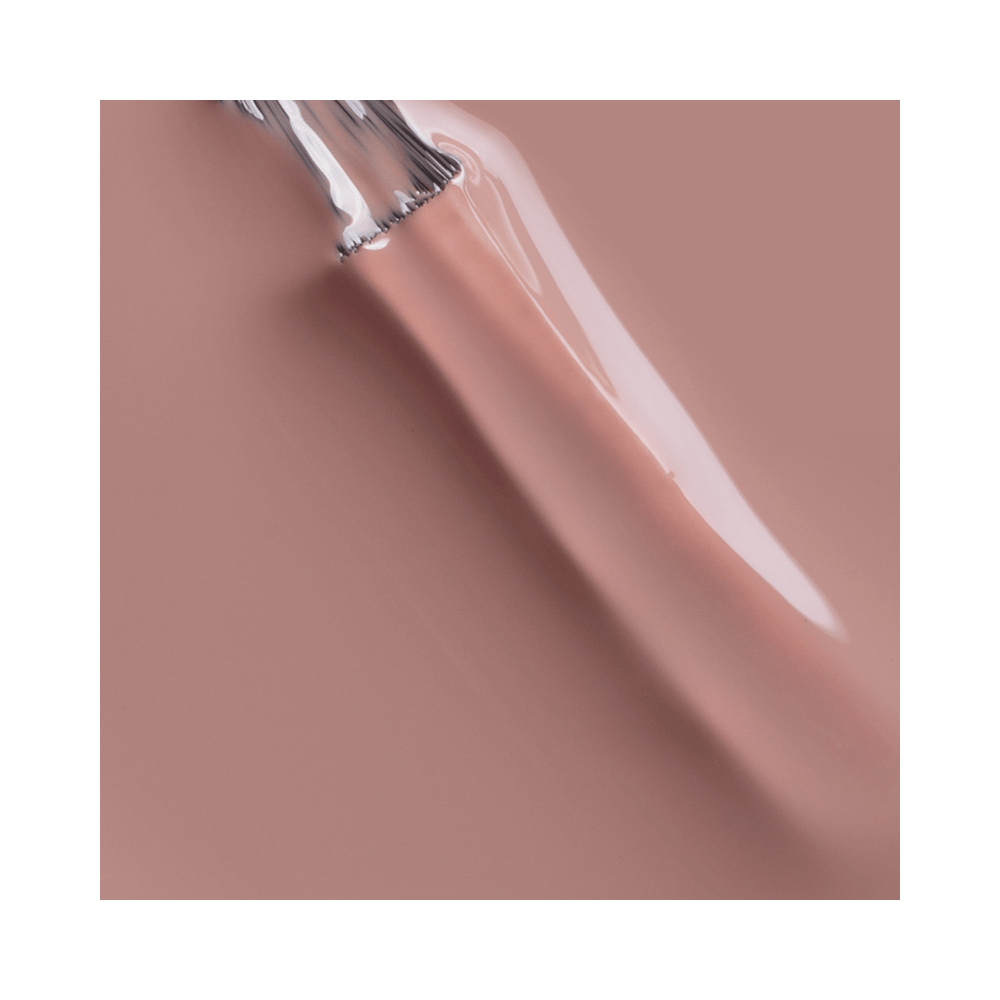Close do pincel aplicador carregado com esmalte cremoso marrom rosado