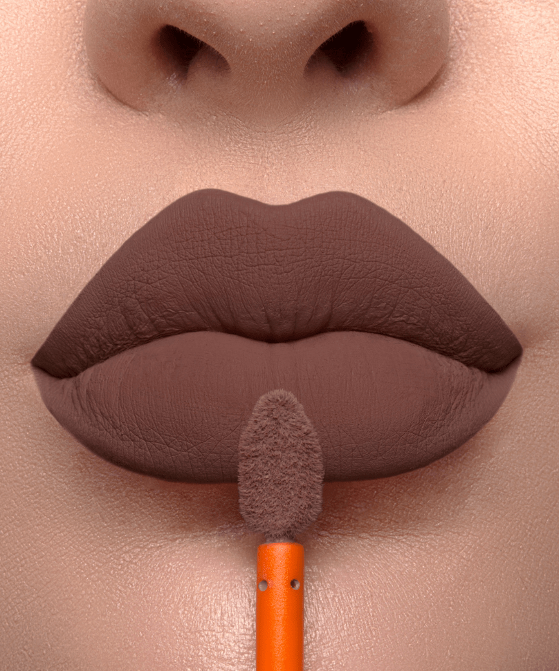 Aplicador do batom Creamy Matte Lush em close nos lábios de modelo