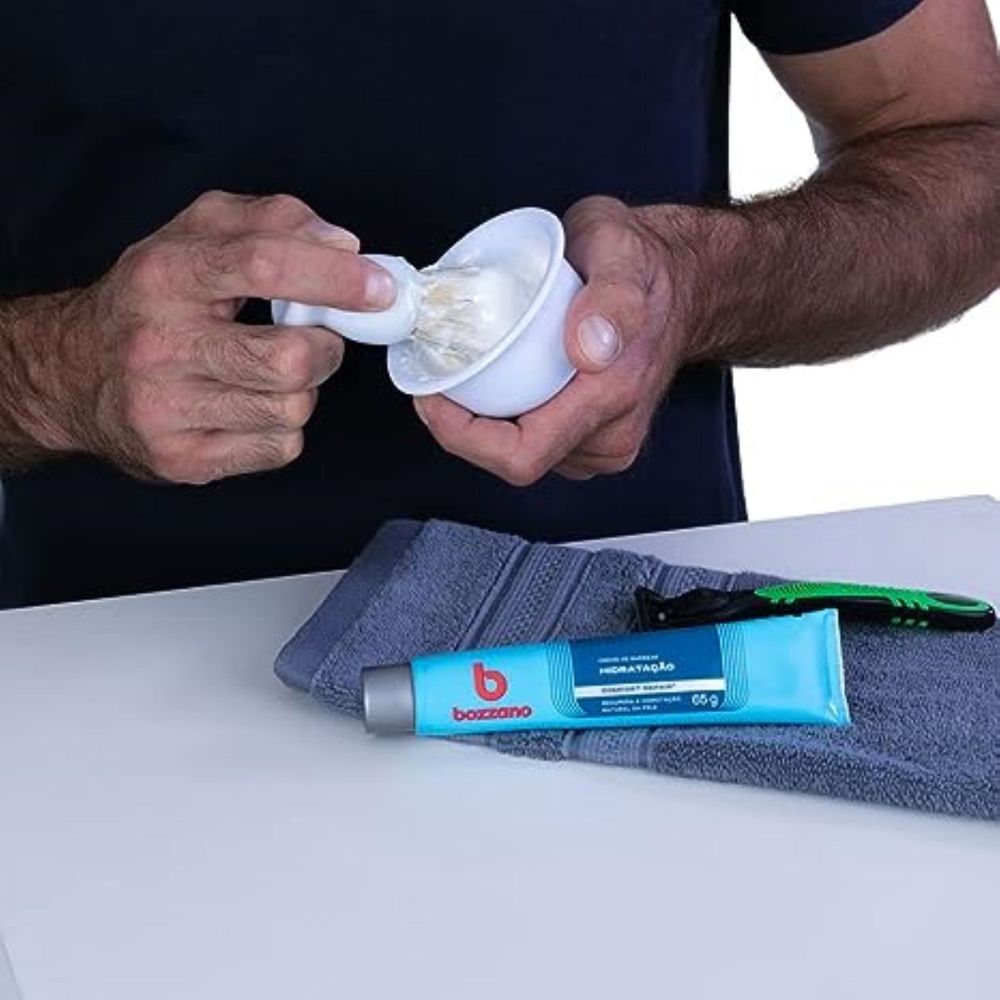 Aplicação do creme de barbear Bozzano com pincel ao lado do aparelho de barbear