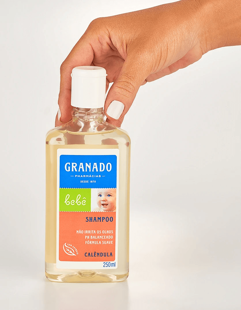 Mão segurando frasco do Shampoo Granado Baby Calêndula