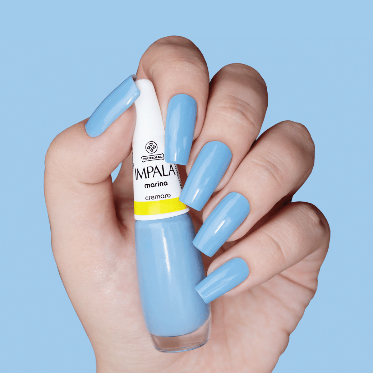 Mão segurando frasco do Esmalte Impala Cremoso Marina com unhas pintadas