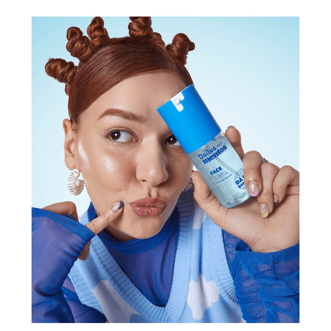 Pessoa segurando a Bruma Tonificante Facial Dailus Mentos Face Mist 100ml próxima ao rosto