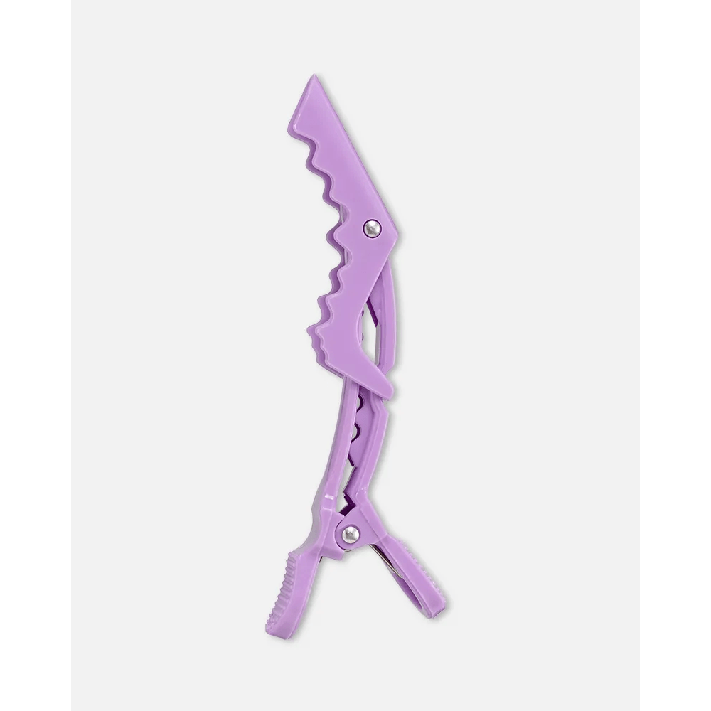 Clip crocodilo lilás aberto em vista lateral mostrando dentes e articulação metálica