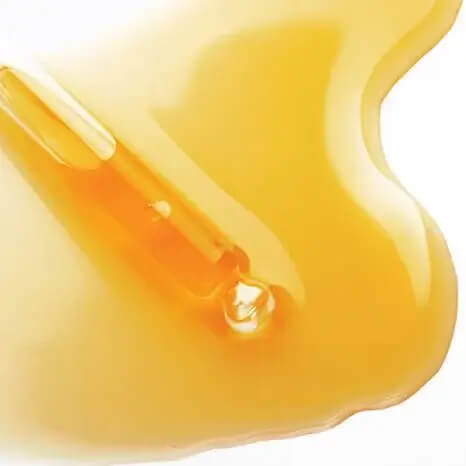 Gota de óleo dourado representando óleos nutritivos na fórmula