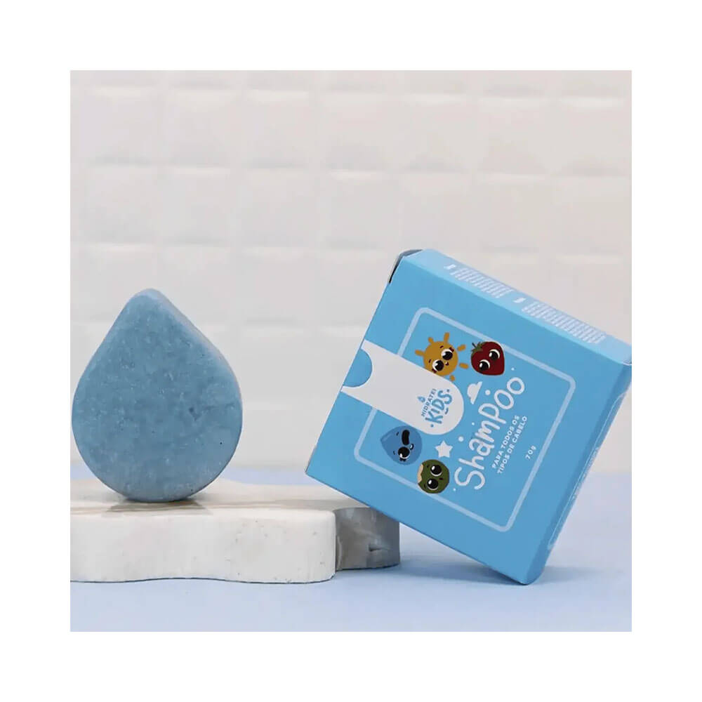 Shampoo Hidratei Sólido Kids 70g ao lado da caixa em ambiente clean infantil