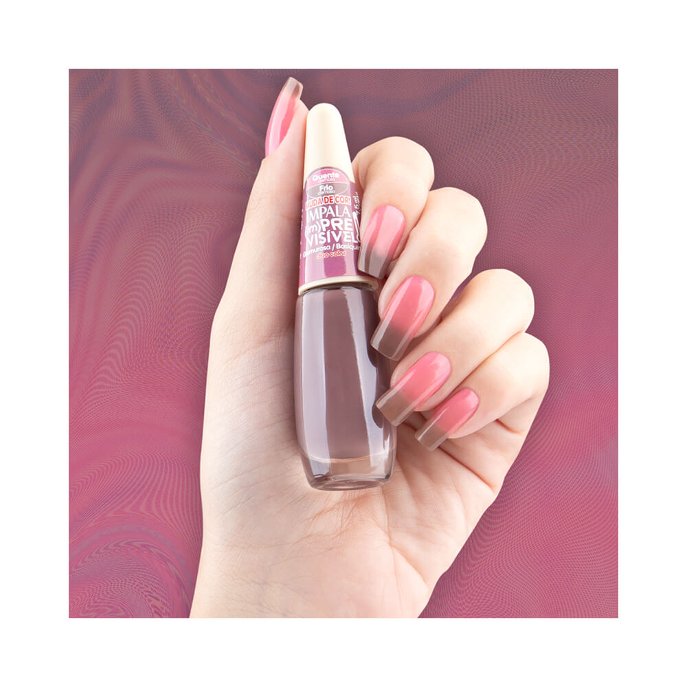 Mão segurando o esmalte mostrando a mudança de cor do rosa ao marrom