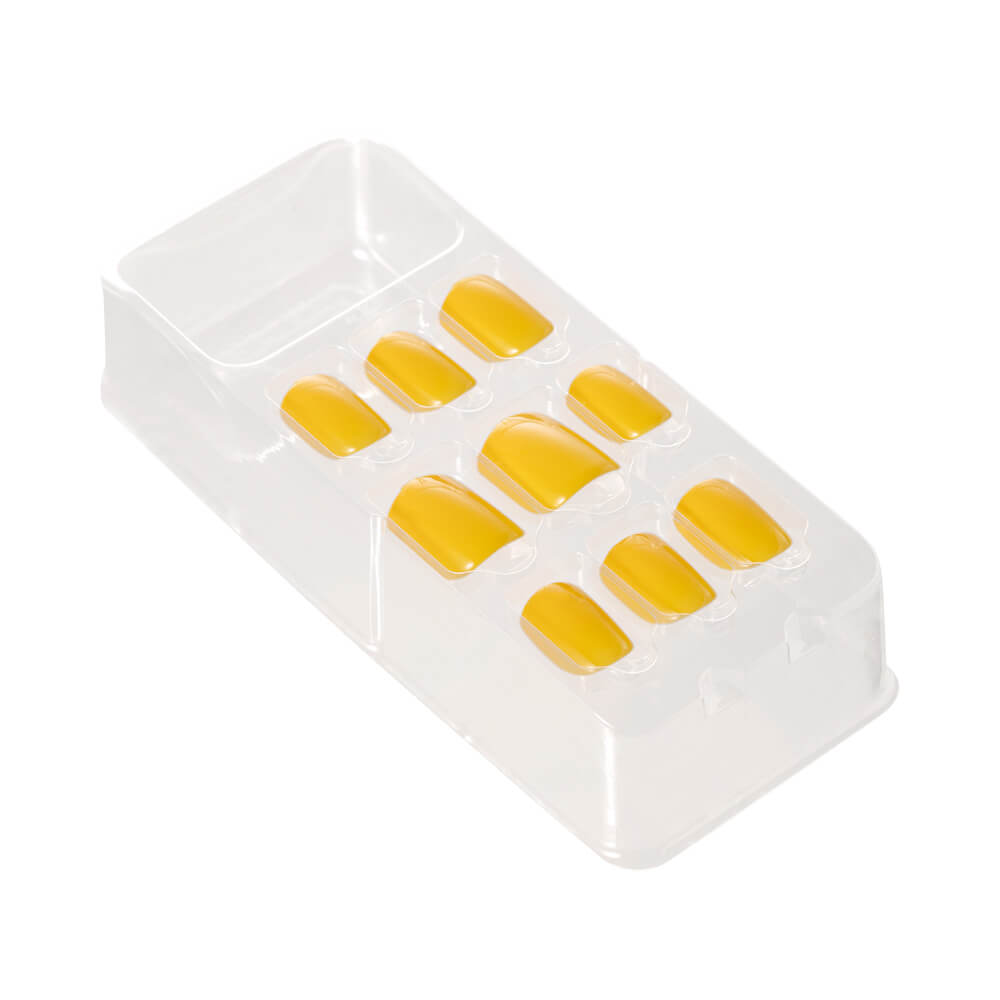 Bandeja com unhas autocolantes amarelas quadradas curtas mostrando acabamento brilhante