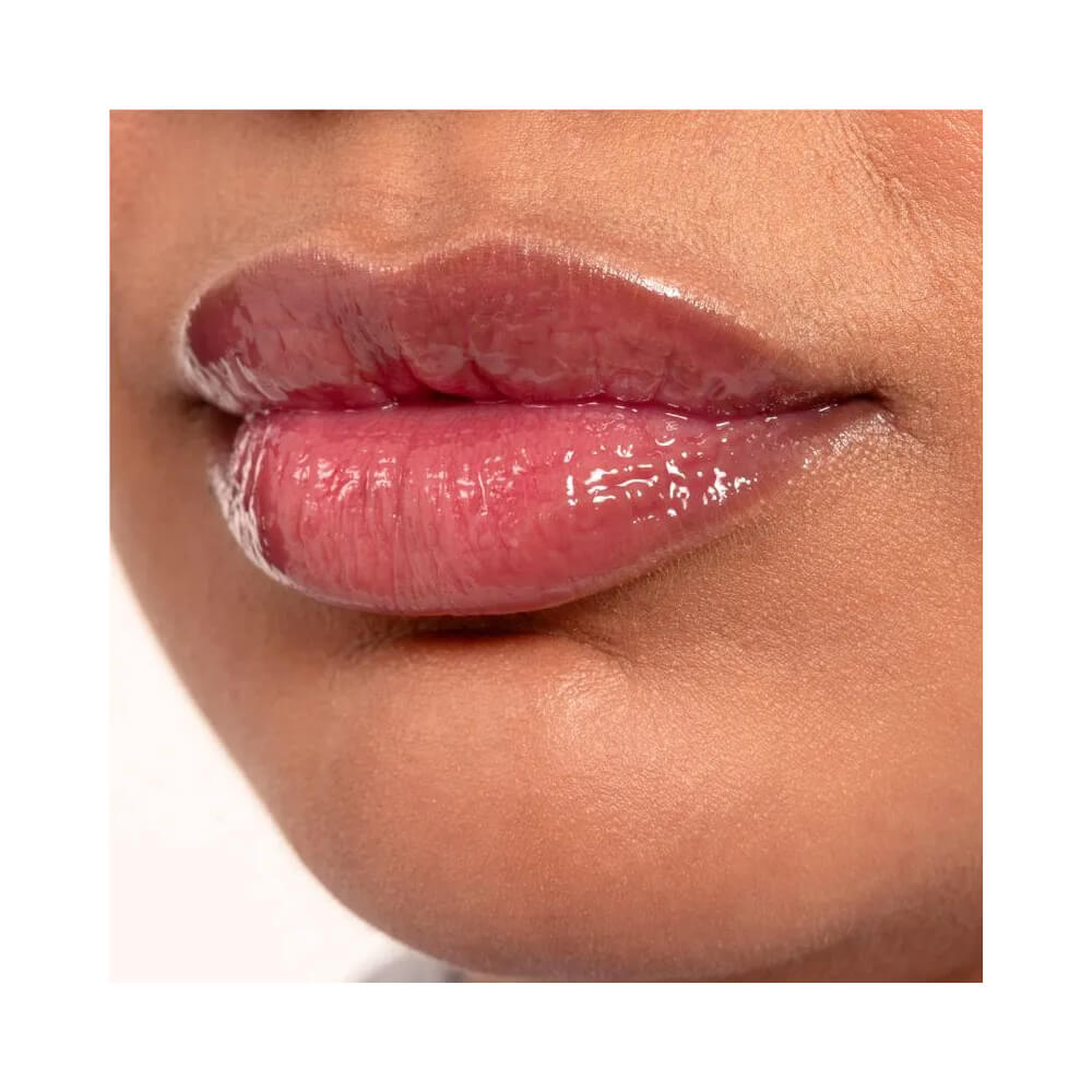 Lip Oil Ruby Kisses Jelly Pop apoiado sobre blueberries, destacando cor e embalagem