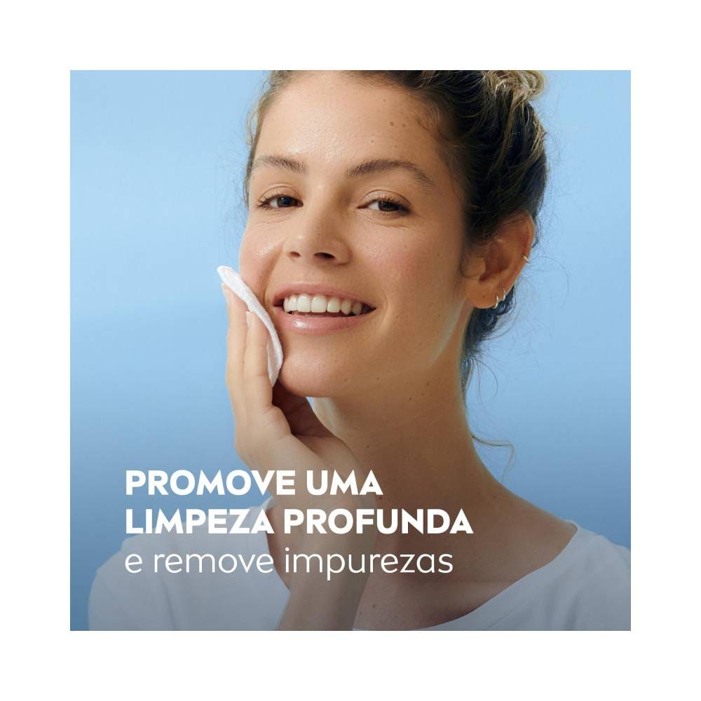 Mulher aplicando a loção 2 em 1 Nivea no rosto com algodão