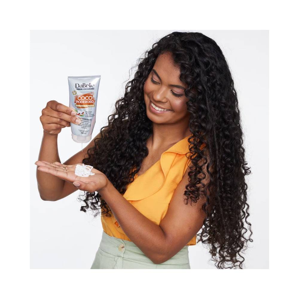 Aplicação da manteiga nutritiva DaBelle em modelo com cabelo cacheado