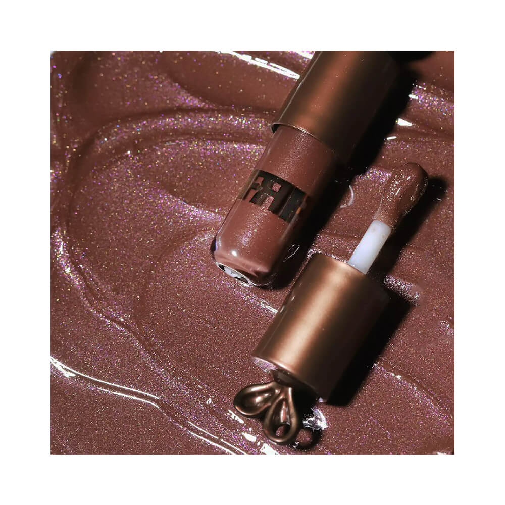 Close do gloss aberto mostrando líquido brilhante marrom com cintilância rosa