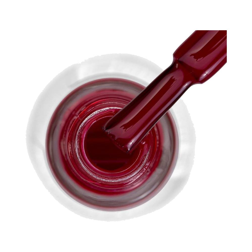 Detalhe do pincel mergulhado no esmalte vermelho cremoso