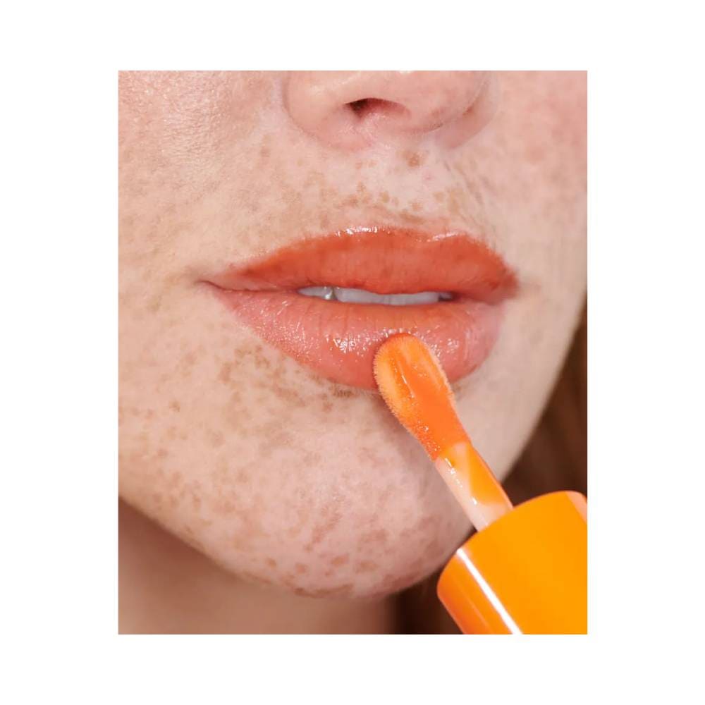 Aplicação do Lip Juice Mari Maria Tangerina nos lábios mostrando brilho e cor vibrante