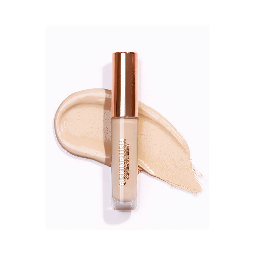 Corretivo Bruna Tavares Skinplush F3040 aplicado em superfície branca com embalagem transparente e tampa dourada