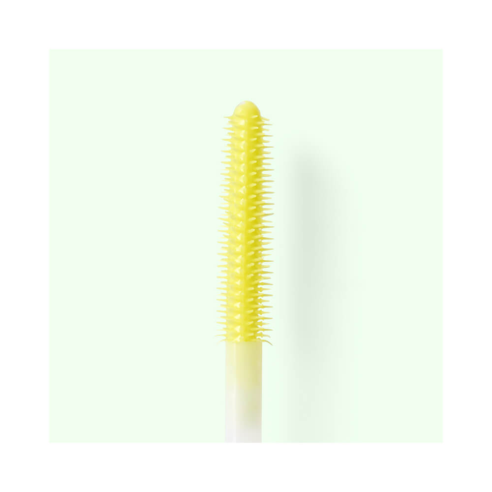 Detalhe do aplicador amarelo com cerdas cilíndricas finas da Máscara Melu Vibe Praiana