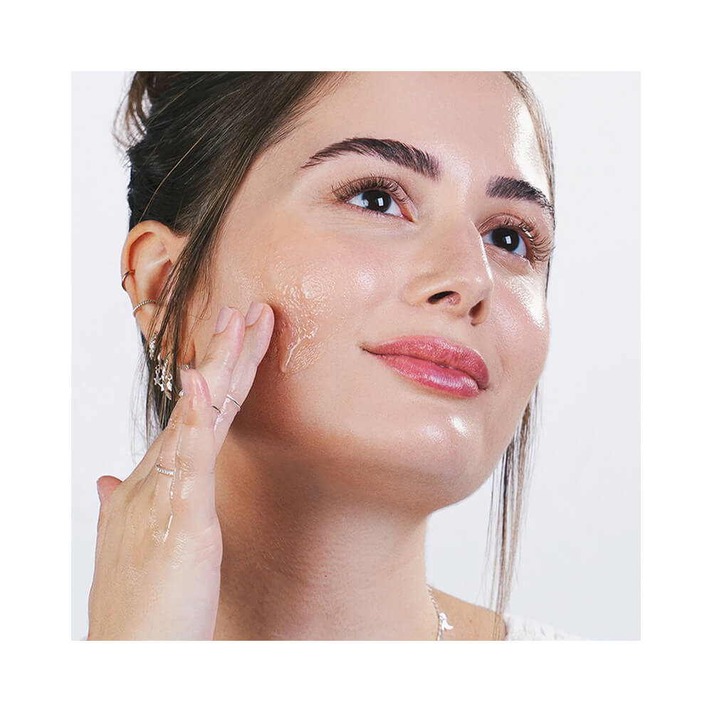 Aplicação do gel transparente na bochecha, mostrando textura leve e refrescante
