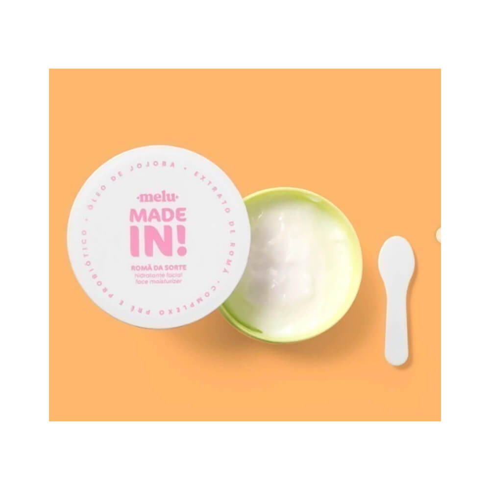 Pote aberto do hidratante facial Melu Made In! Romã da Sorte 50g mostrando creme branco e espátula