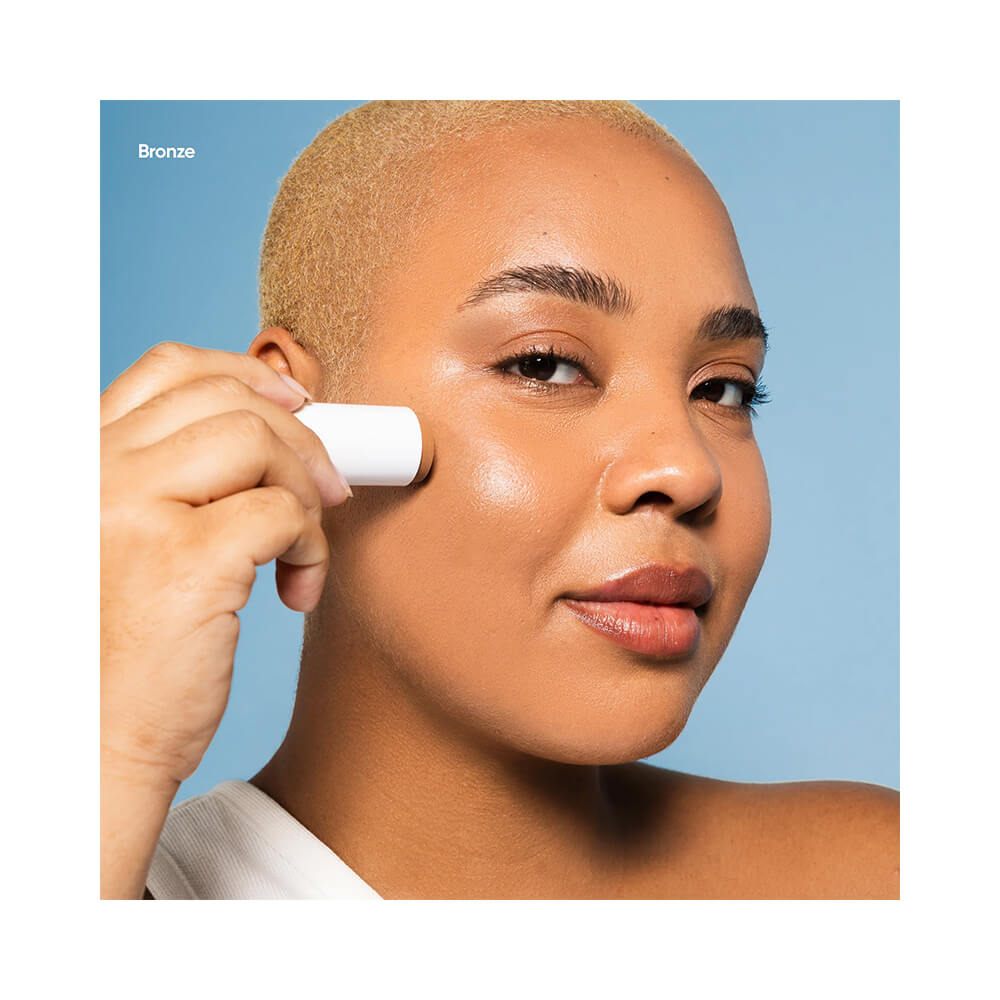 Mulher aplicando Stick Multifuncional Beyoung Bronze no rosto, mostrando aplicação prática