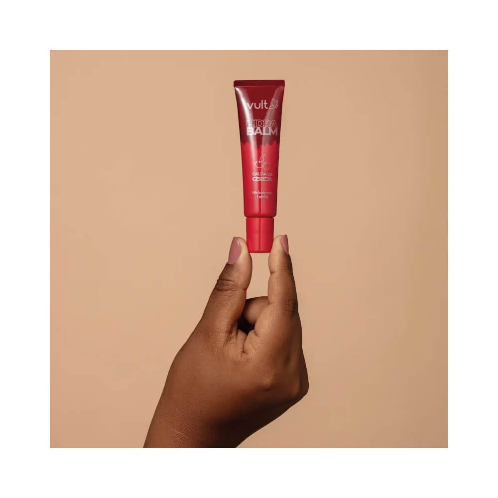 Mão segurando Hidratante Labial Vult Hidra Balm Calda de Cereja