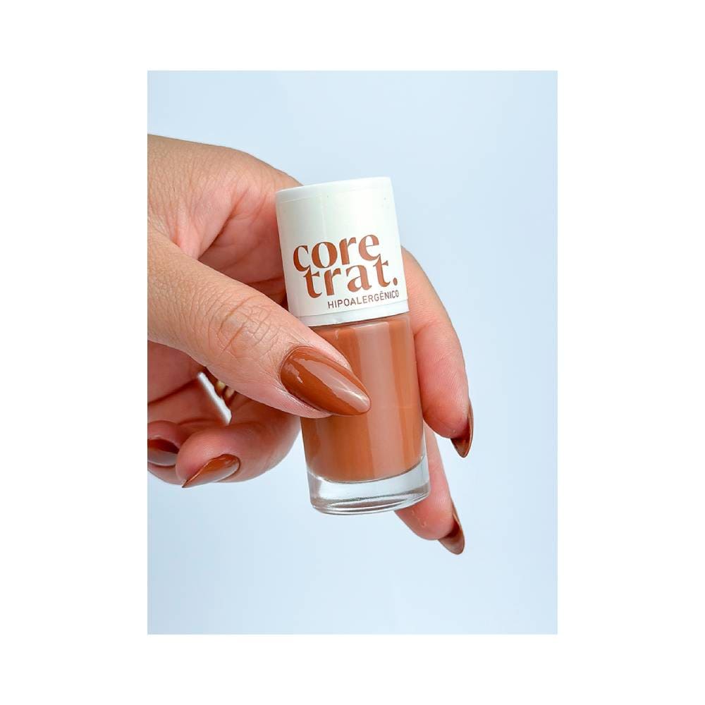 Mão com unhas pintadas com Esmalte Blant Coretrat Cremoso Café ao Leite segurando o frasco do produto