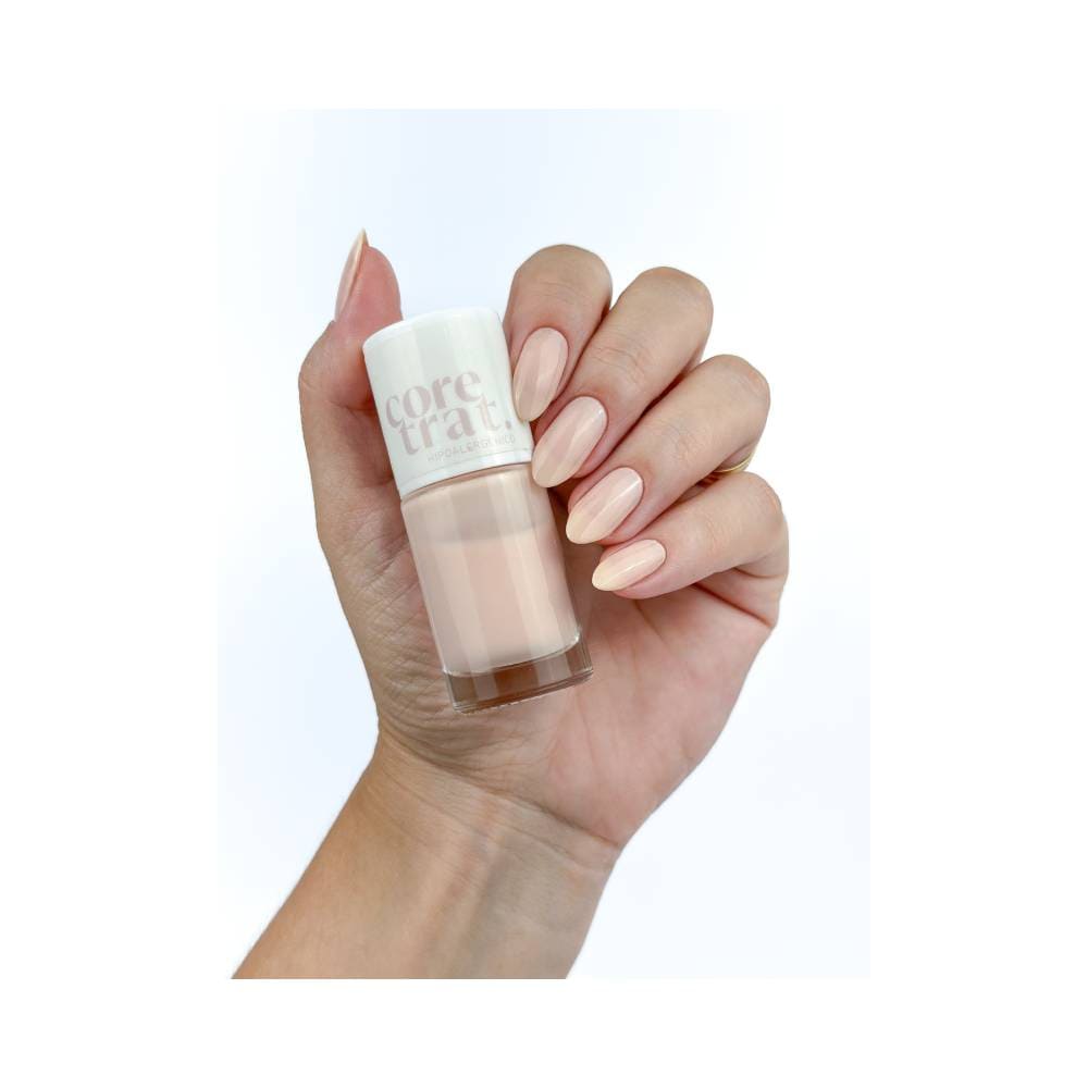 Mão feminina com unhas pintadas com esmalte Blant Coretrat Cremoso Pequeno Gesto bege claro
