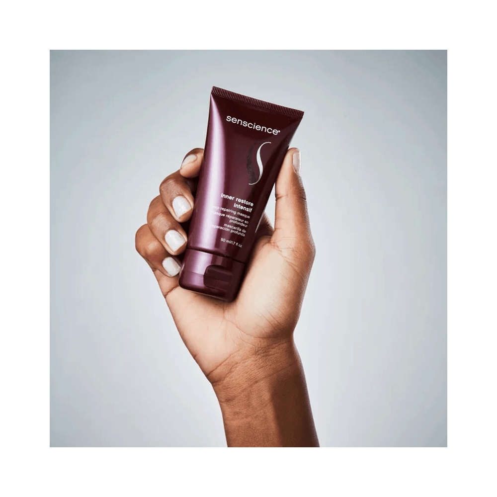 Máscara Senscience Inner Restore Intensif 150ml - bisnaga segurada sobre fundo degradê