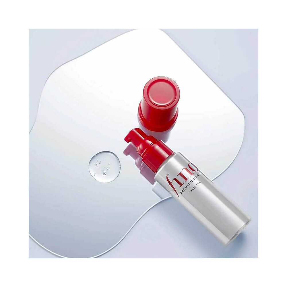 Frasco prateado do Óleo Capilar Fino Premium Touch Hair Oil 70ml com pump vermelho e gota do produto