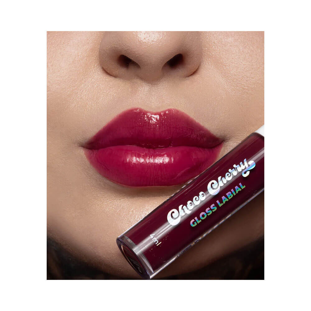 Lábios com gloss Dailus Choco Cherry em tom cereja escuro, mostrando brilho intenso