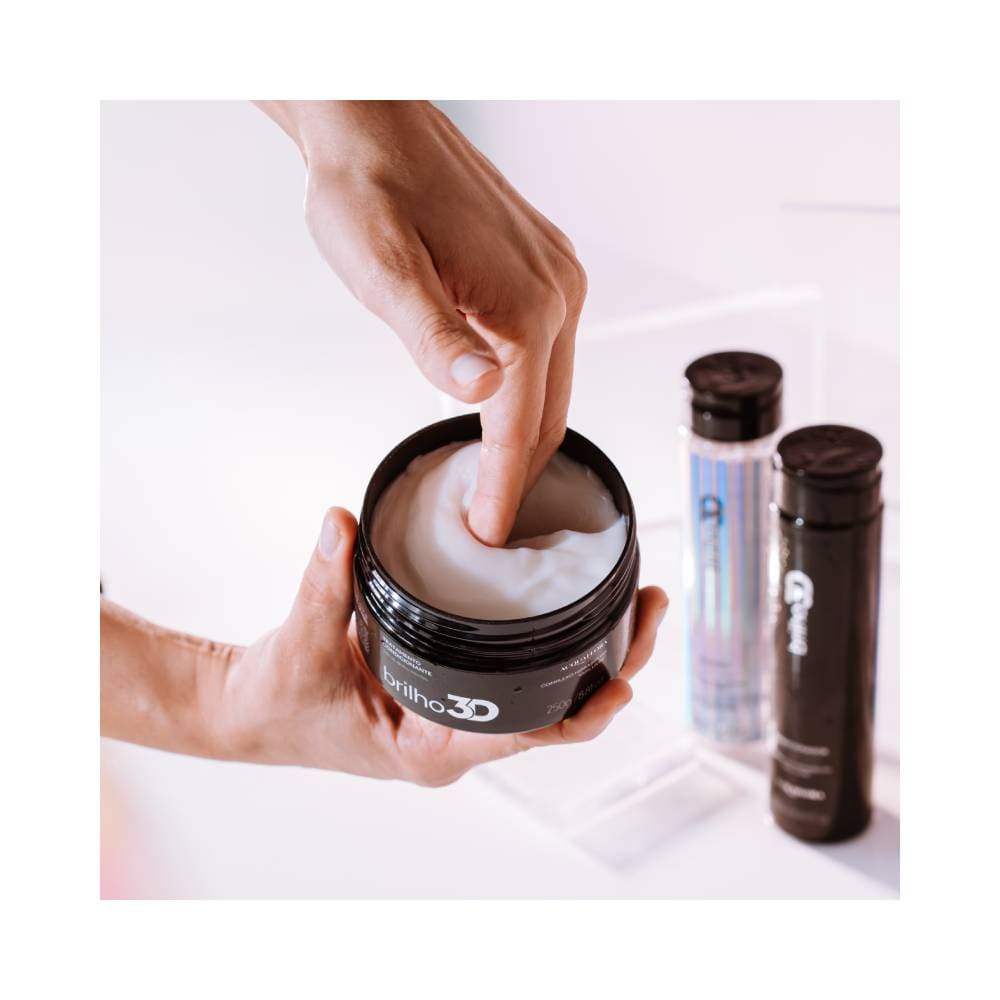 Mão aplicando a Máscara Acquaflora Brilho 3D mostrando textura cremosa