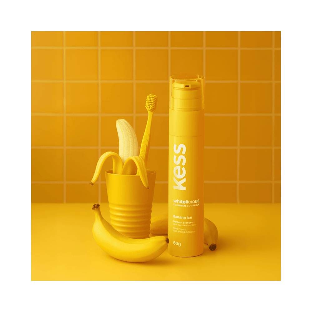 Gel Dental Kess Whitelicious Banana Ice ao lado de banana e escova de dentes amarela