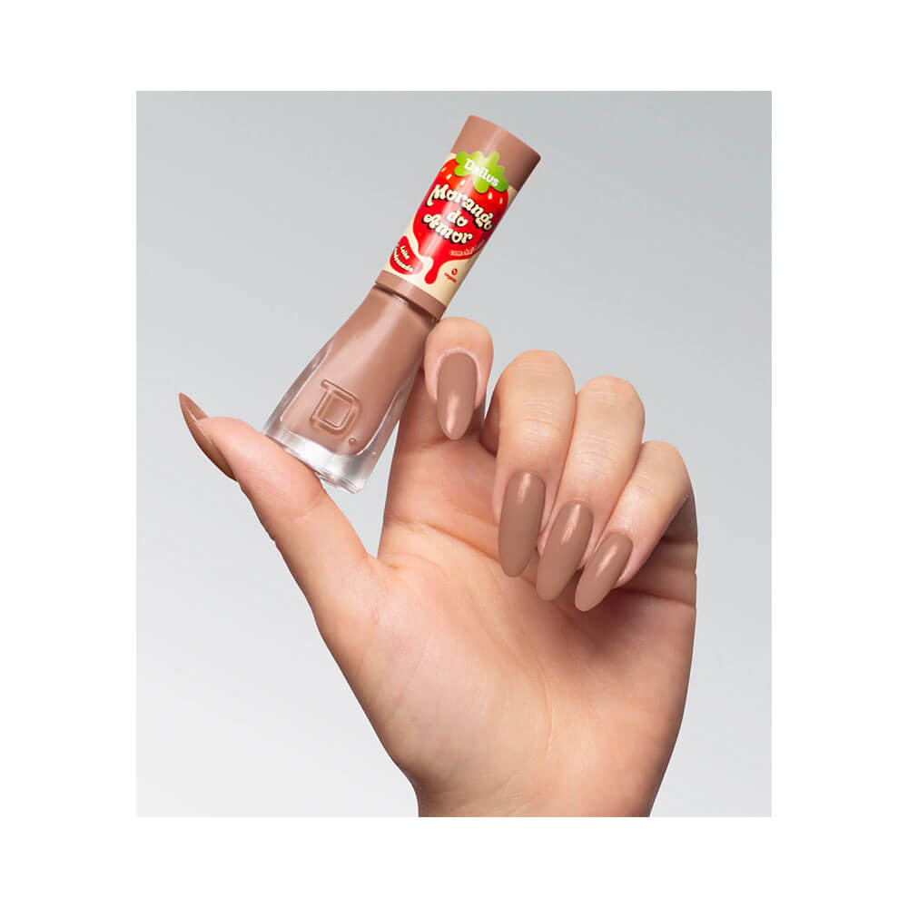 Mão segurando o esmalte Dailus Morango do Amor Leite Condensado com unhas pintadas