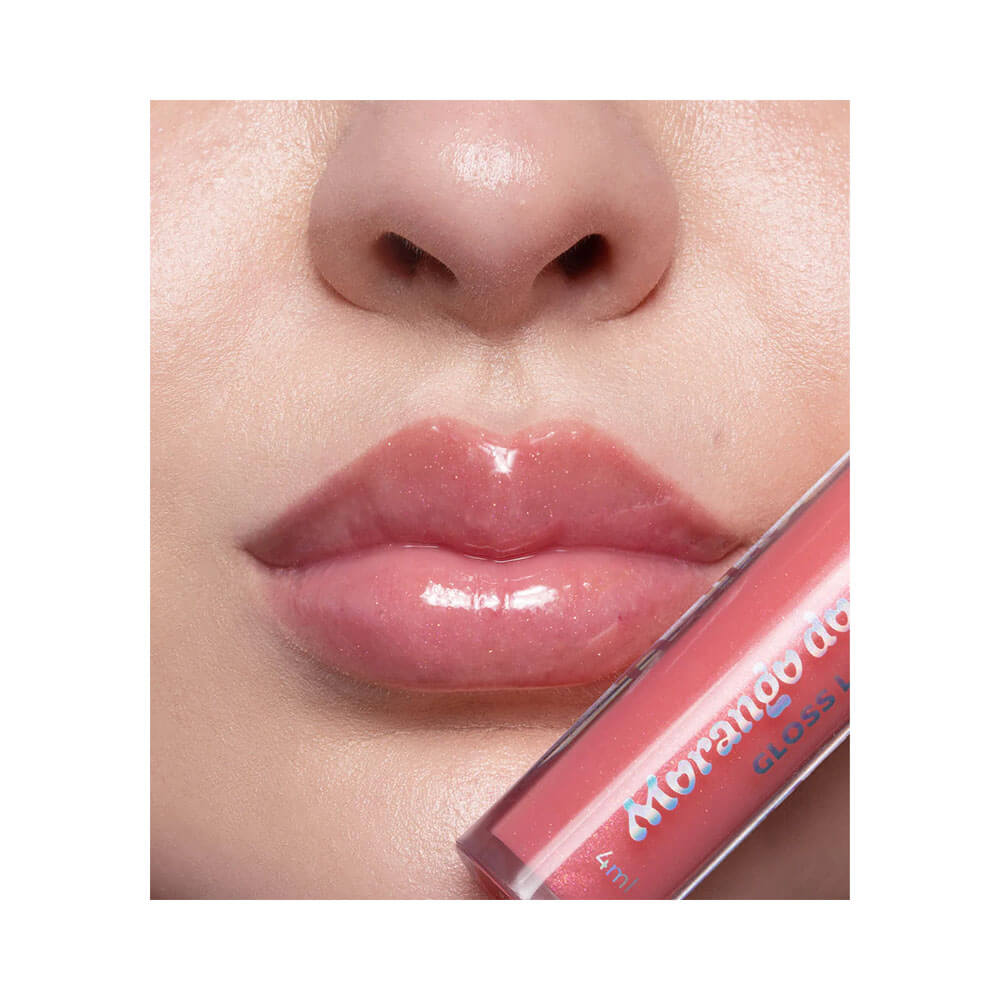 Close nos lábios usando Lip Gloss Dailus Morango do Amor Calda de Açúcar mostrando brilho e cor rosada translúcida