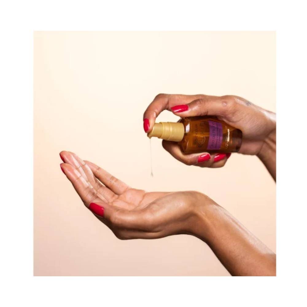 Mãos aplicando o elixir capilar Beauty Color óleo de rícino em cabelos