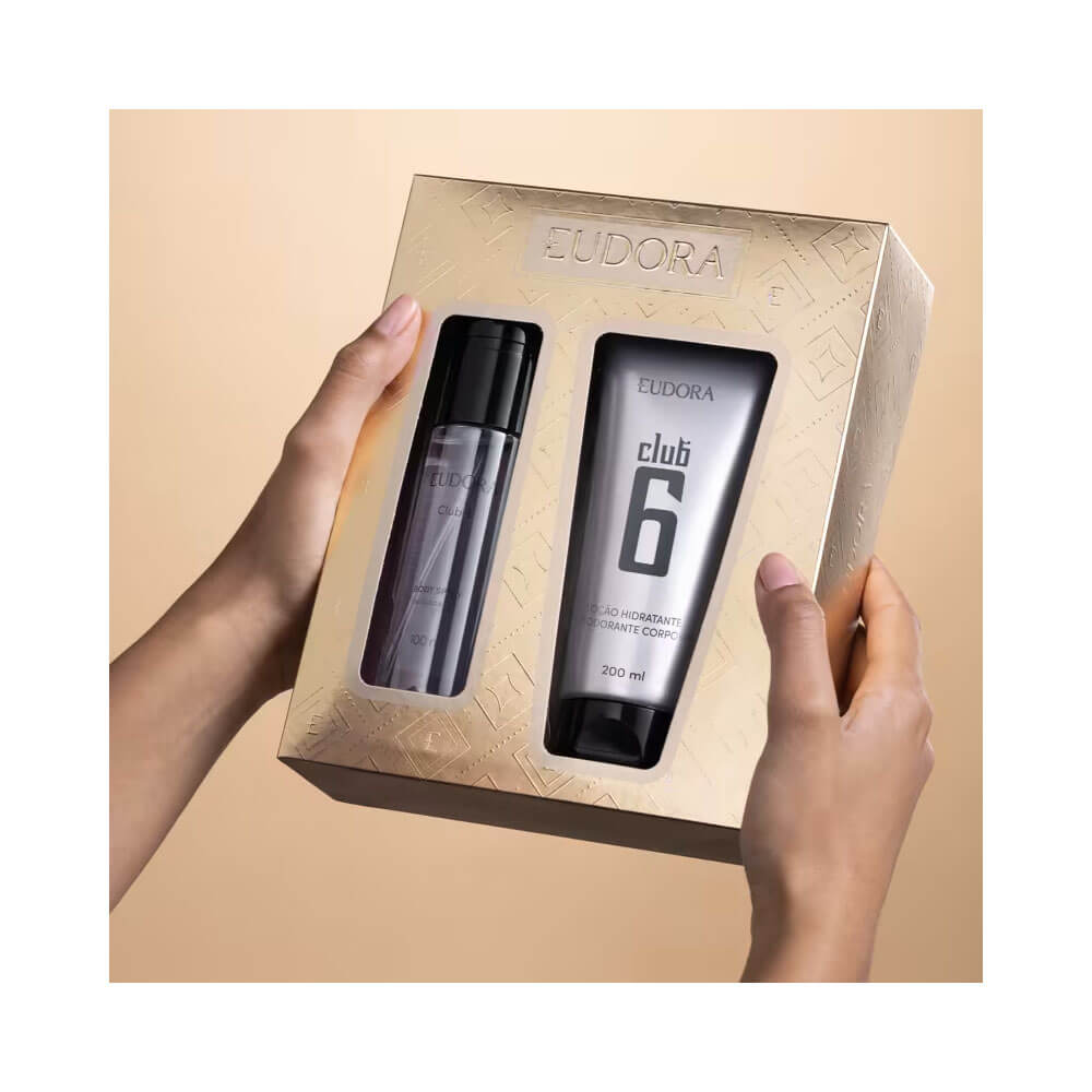 Mãos segurando o Kit Eudora Club 6, mostrando embalagem dourada e produtos visíveis