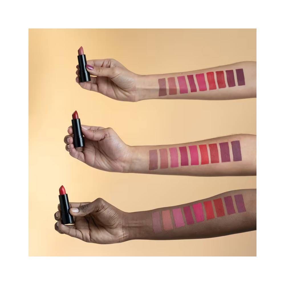 Braços com diferentes tons de pele segurando batons Vult Matte Lips mostrando variedade de cores