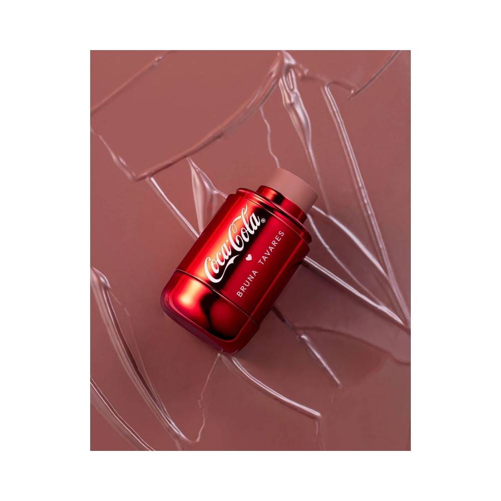 Blush Stick Bruna Tavares Coca-Cola Classic Brown posicionado sobre fundo rosa com efeito transparente