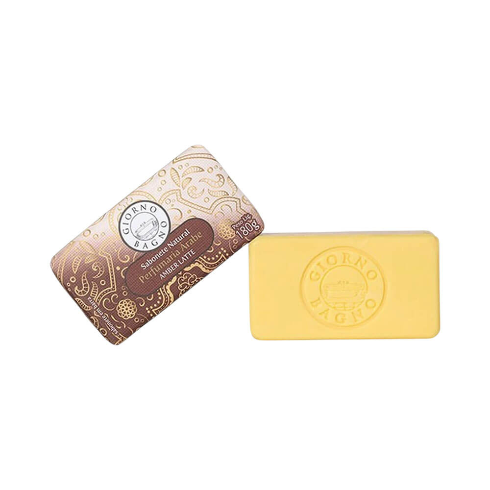 Sabonete Giorno Bagno Amber Latte barra amarela clara ao lado da embalagem marrom com detalhes dourados