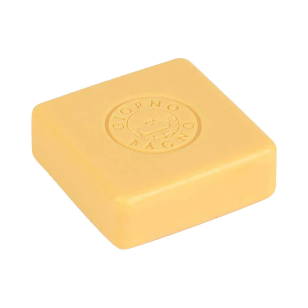 Sabonete Giorno Bagno Bergamota e Patchouli 100g amarelo claro, formato quadrado com bordas arredondadas e logo em relevo