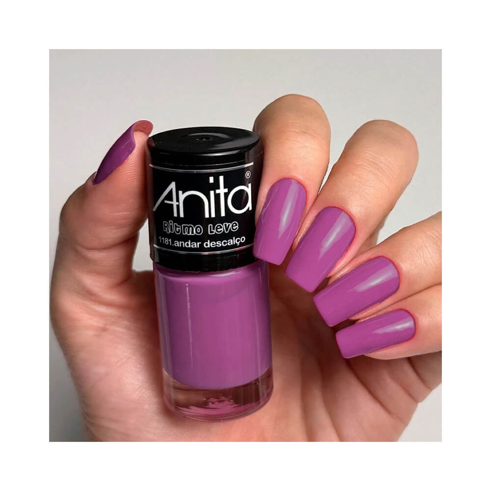 Mão segurando esmalte Anita Ritmo Leve Andar Descalço com unhas pintadas