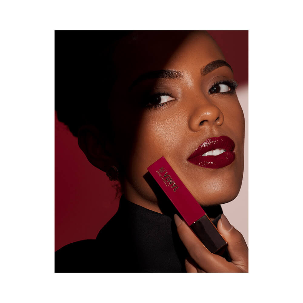 Mulher aplicando batom líquido Bruna Tavares Vinyl Diana com cor vermelha intensa