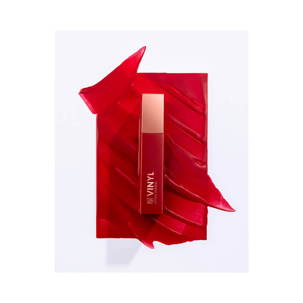 Batom líquido Bruna Tavares Vinyl Sara aplicado em fundo vermelho mostrando textura