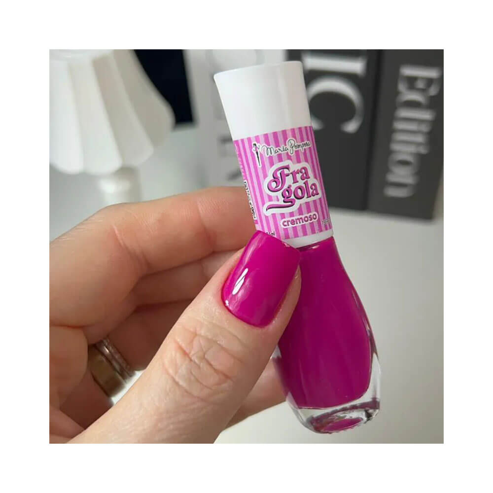 Mão segurando esmalte Maria Pomposa La Dolce Vita Fragola com unha pintada na cor rosa intenso