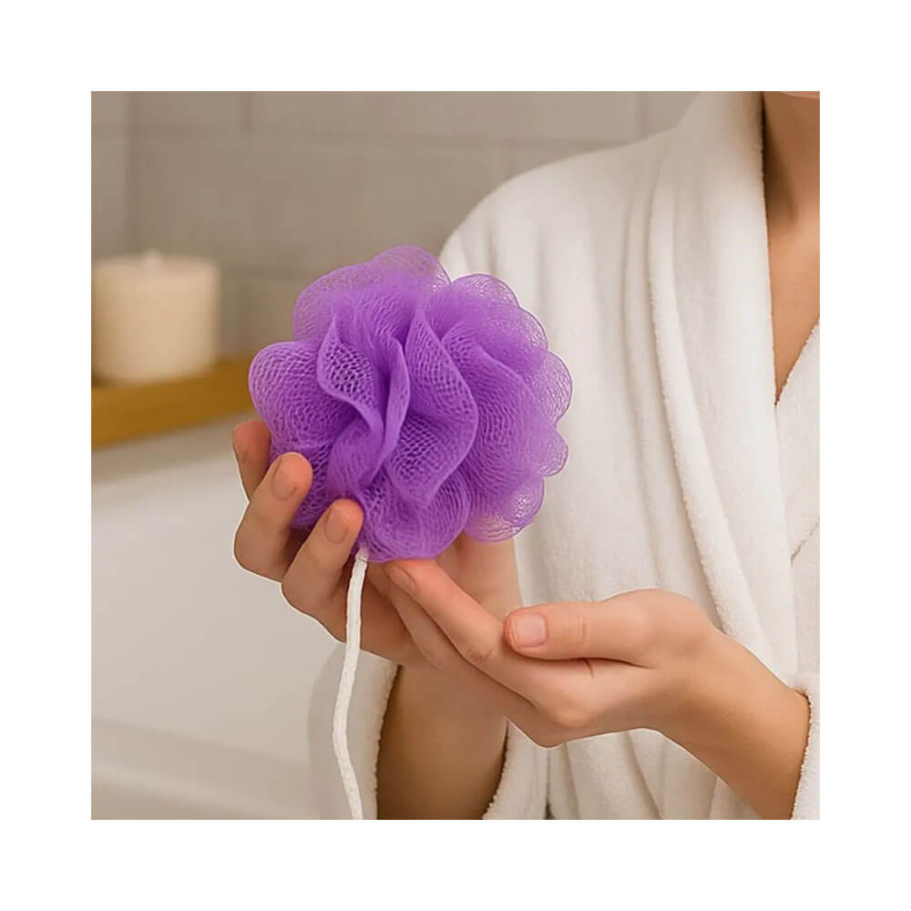 Mão segurando esponja Landh's Nylon roxa com cordão branco em ambiente de banheiro